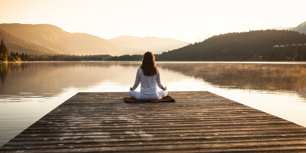 Woman meditating at bridge